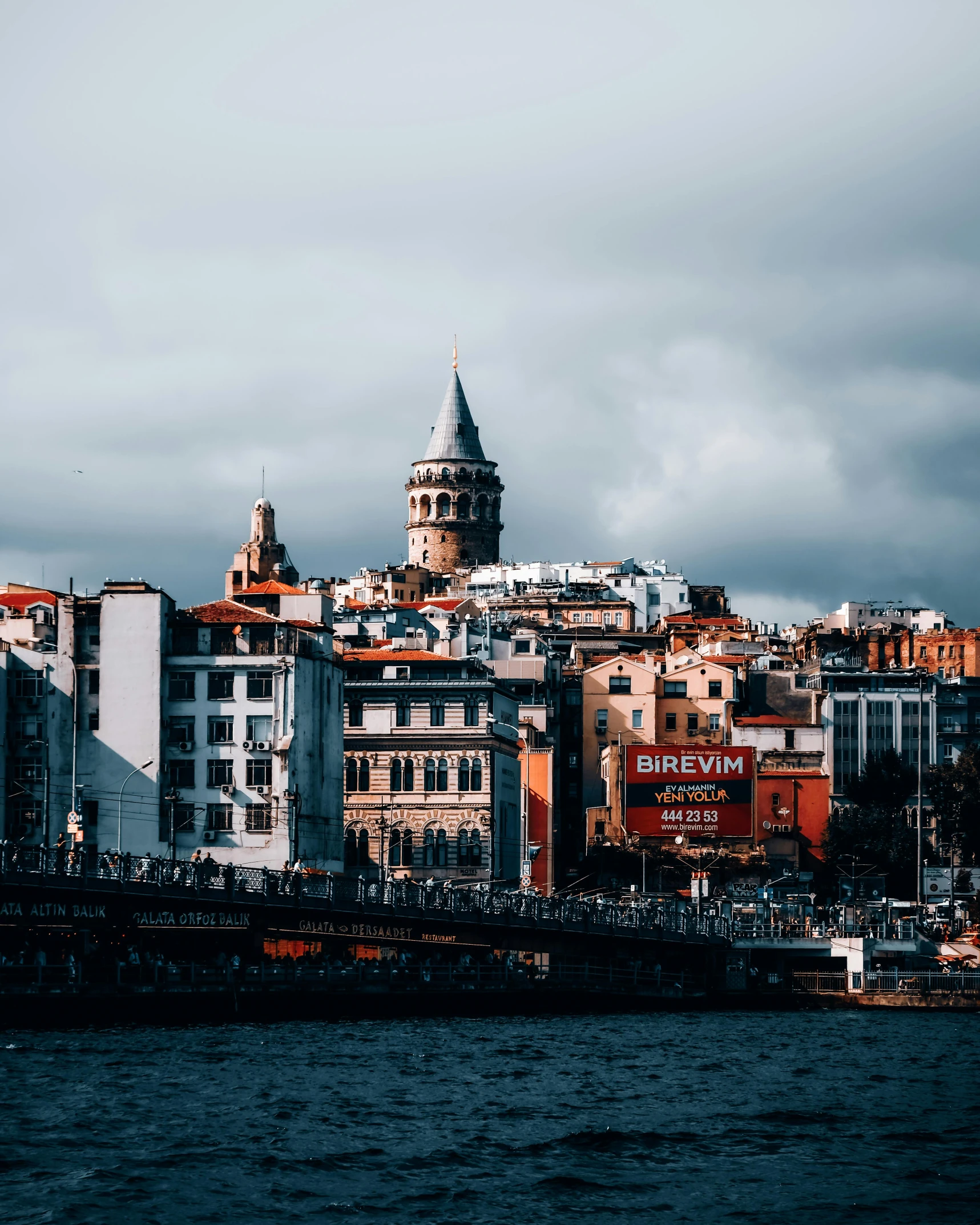 a view of buildings on a cliff overlooking a body of water