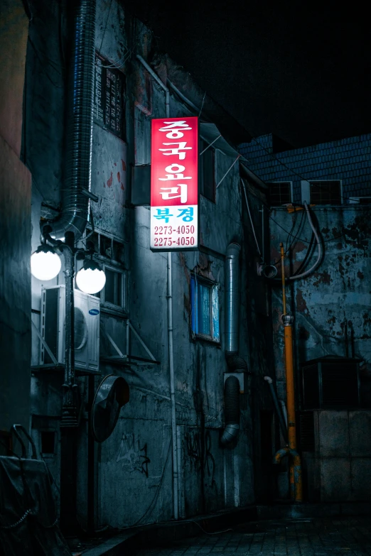 a dark street with a building with signs on it