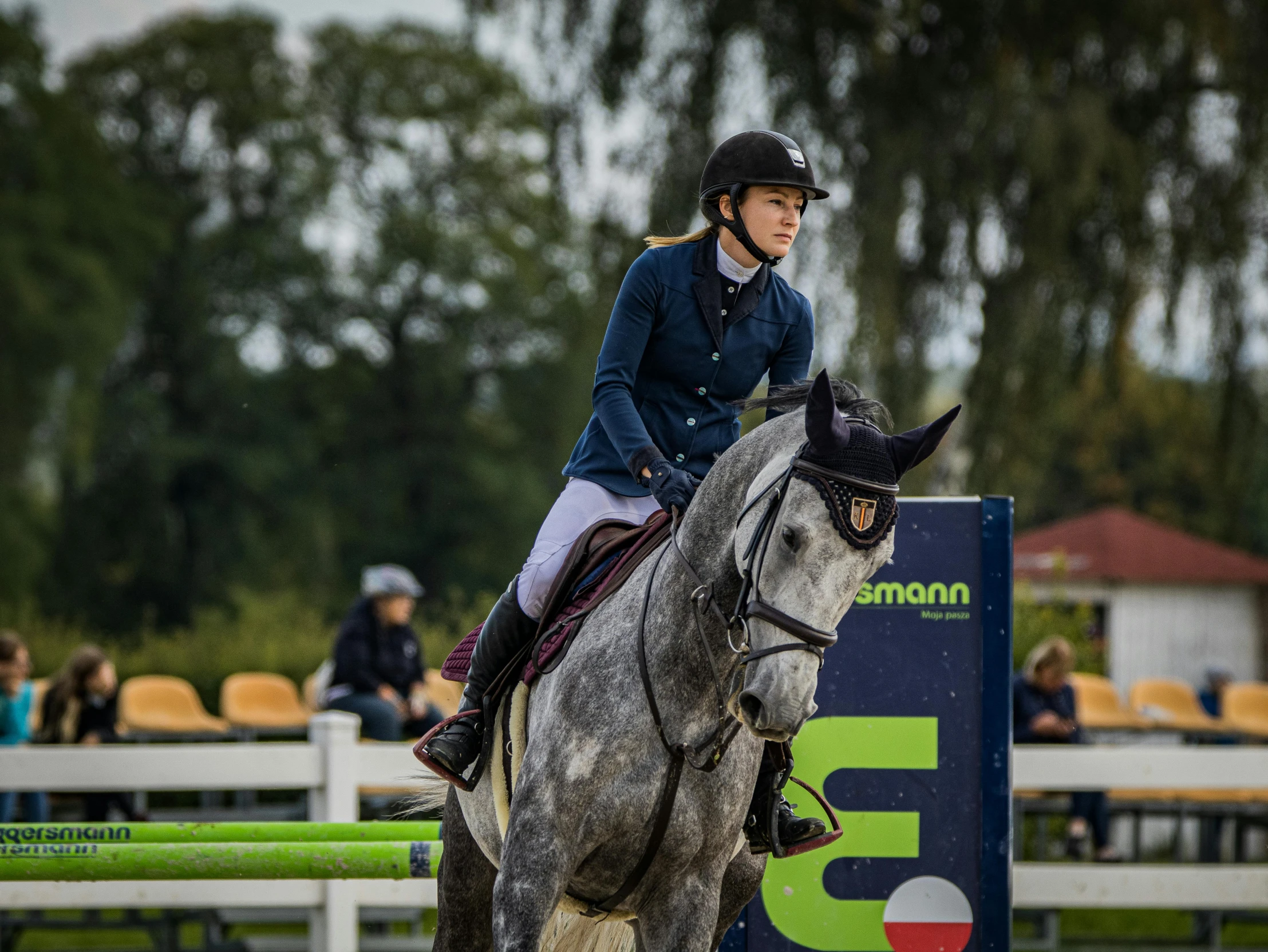 a female jockey is riding her horse around a course