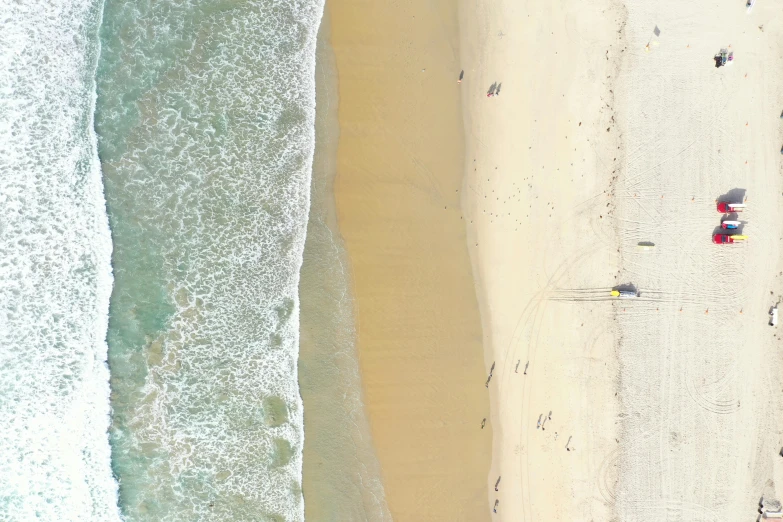 aerial view of an empty beach next to the ocean