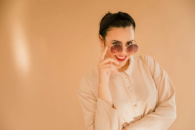 a woman in glasses wearing a long shirt