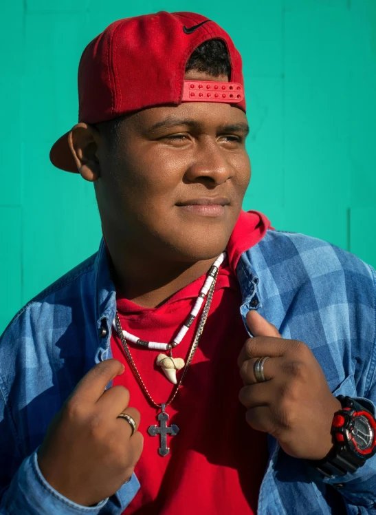 a man with a red shirt and hat poses for the camera