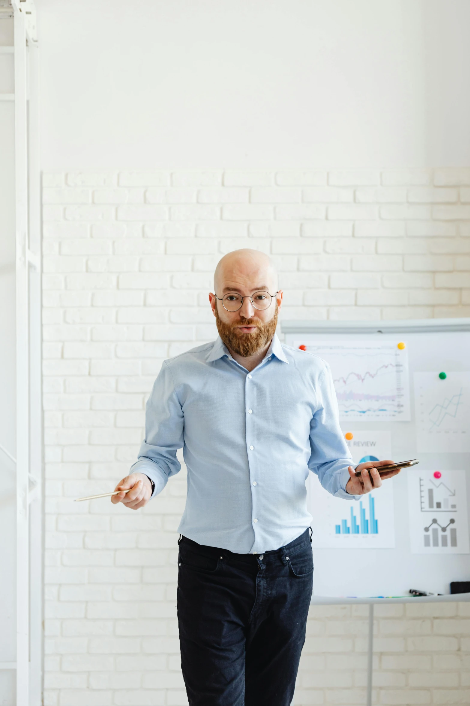 a bearded man with a red beard is standing in front of a whiteboard