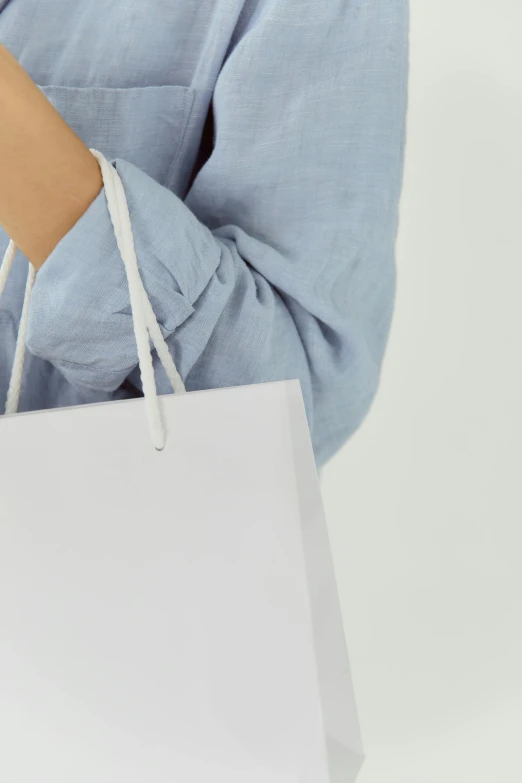 a woman holding white paper bags and shopping bags