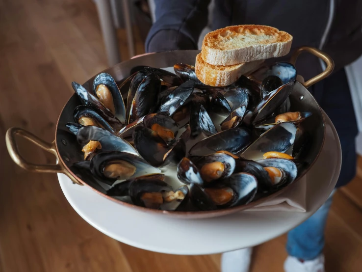 a plate filled with mussels and french bread on top