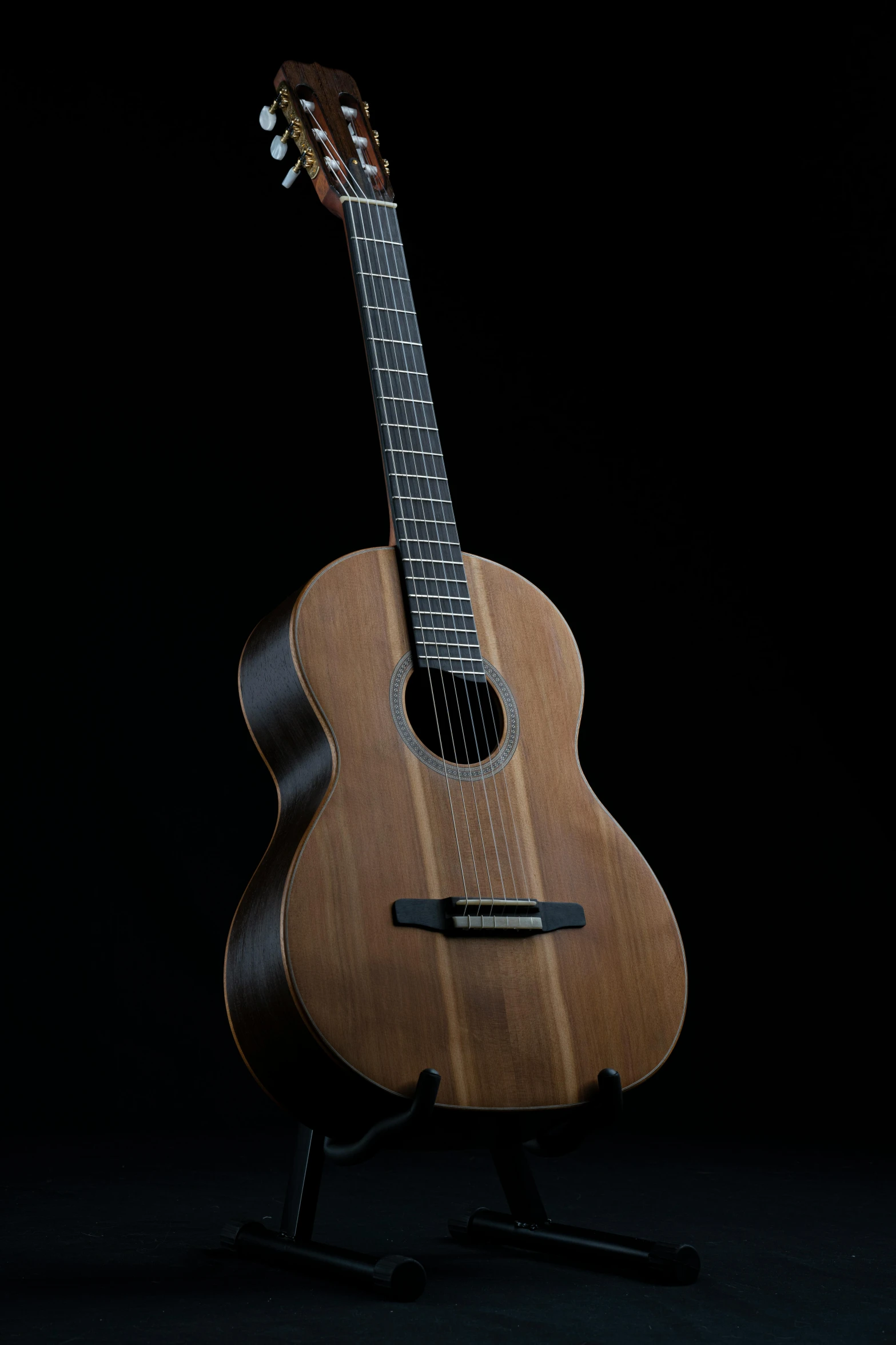 a wooden guitar stands in the dark