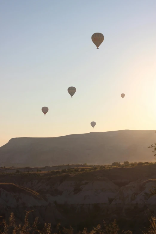 the sun is shining down on many balloons flying through the air