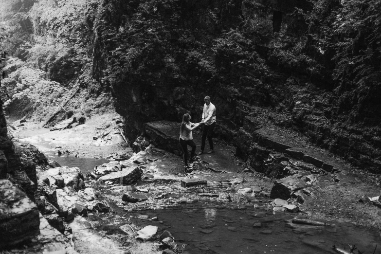 a man and woman standing in the middle of a canyon