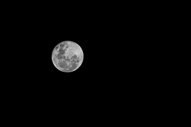 the full moon seen through the black sky