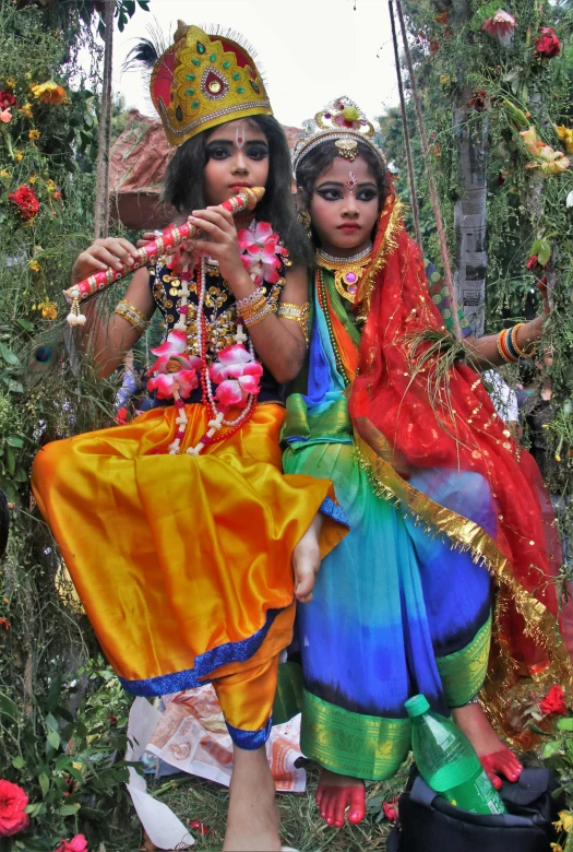 two women with a bright colored costume posing