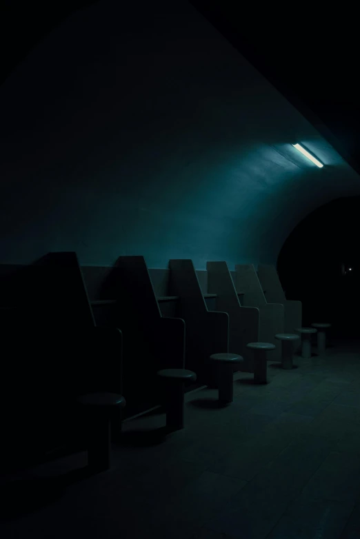 a row of chairs sitting in front of a dimly lit room