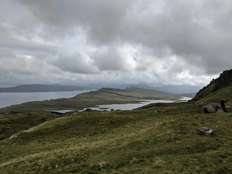 a grassy hill on the edge of a large body of water