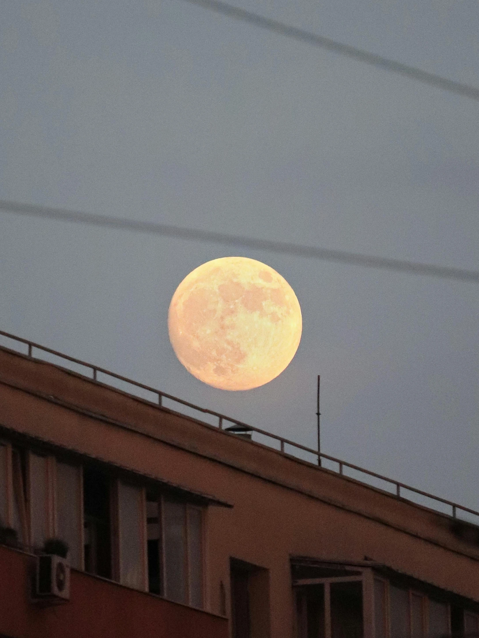 a view from a high rise looking at a full moon