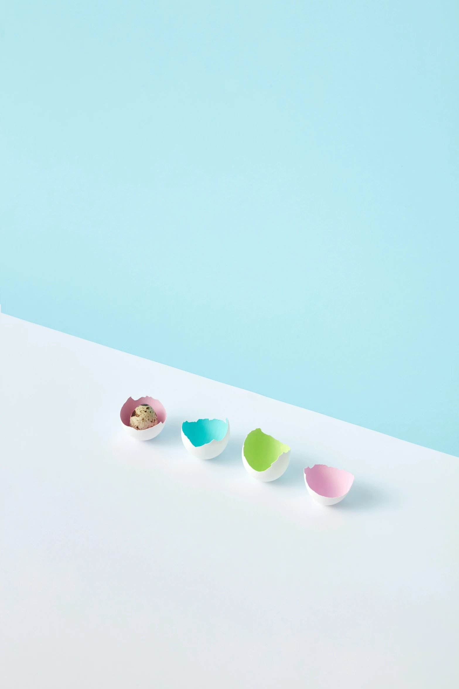 three different colored bowls sit on a white surface