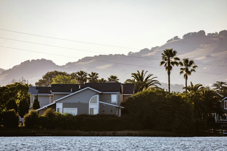 a view of mountains, houses and the water at sunset