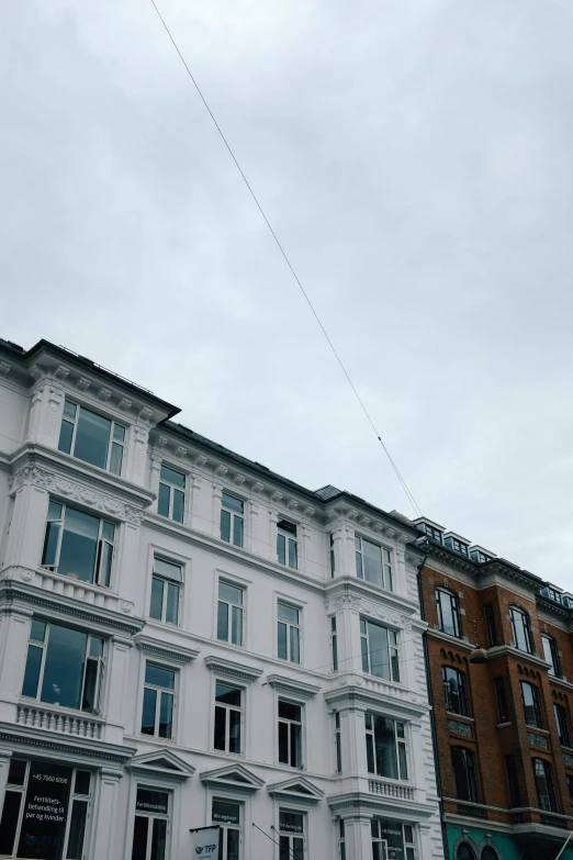 a kite flying high in the air over an apartment building