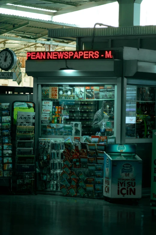 a store front with signs and a clock on the top