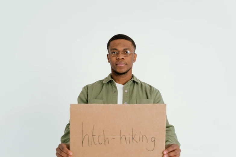 a man holding a cardboard box that reads anti - thinking