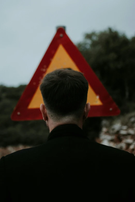 a man standing underneath a red yellow triangle