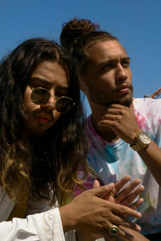 two young people sitting on top of each other in front of some blue sky