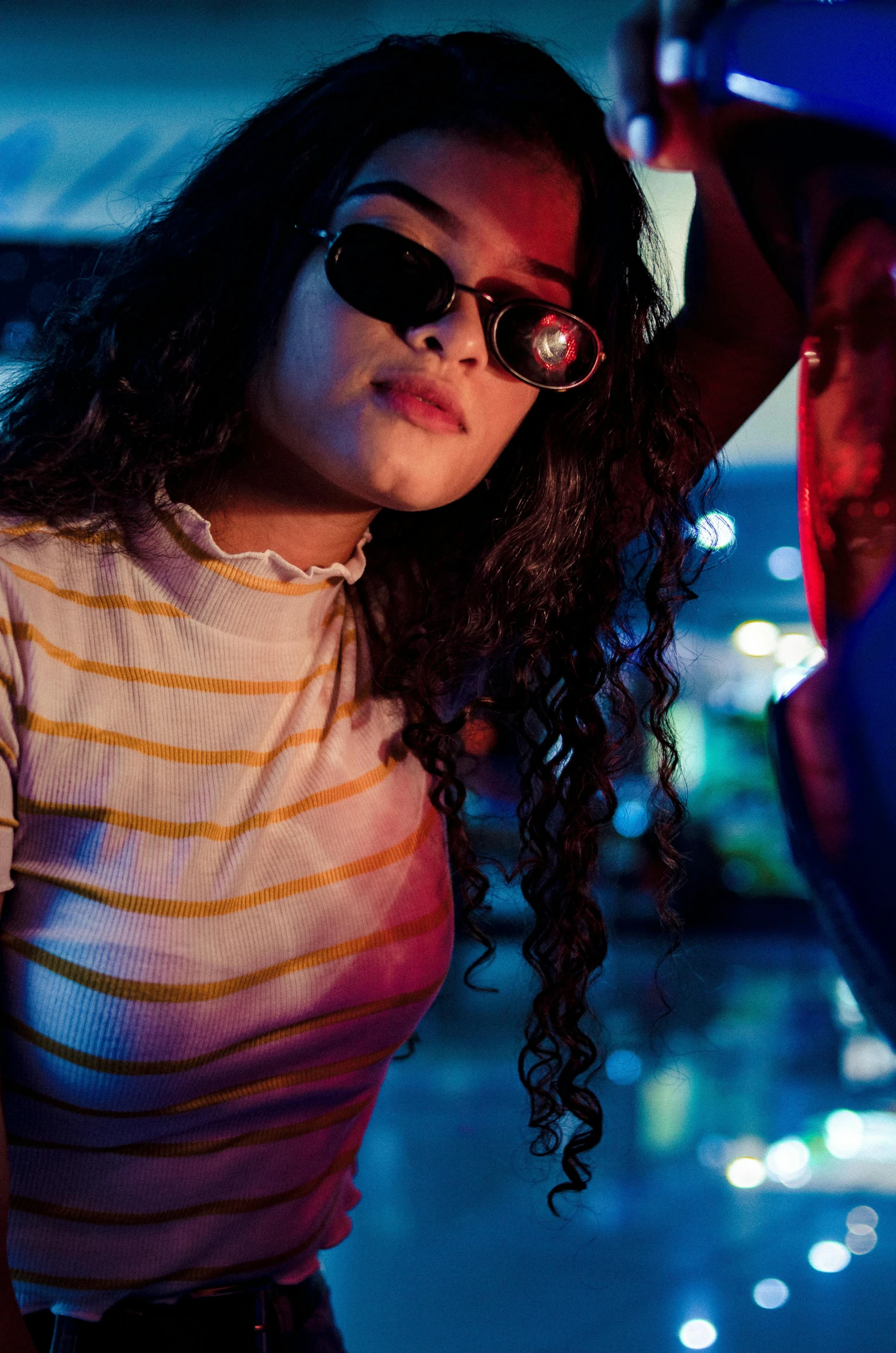 a young woman wearing sun glasses and standing