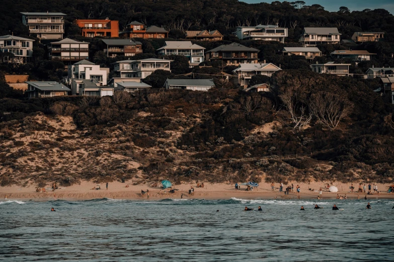 people on the shore watching swimmers on a beach