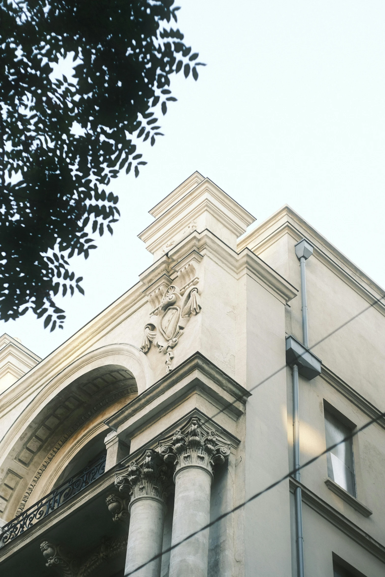 the corner of a tall building with some statues on the side