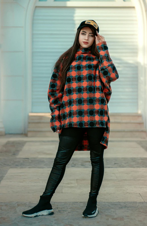 a person is standing up wearing black and orange plaid coat
