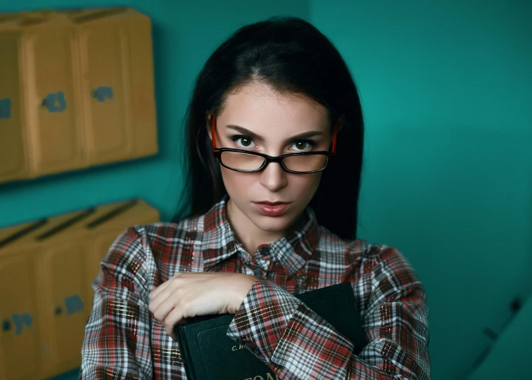 a woman with glasses is holding a binder