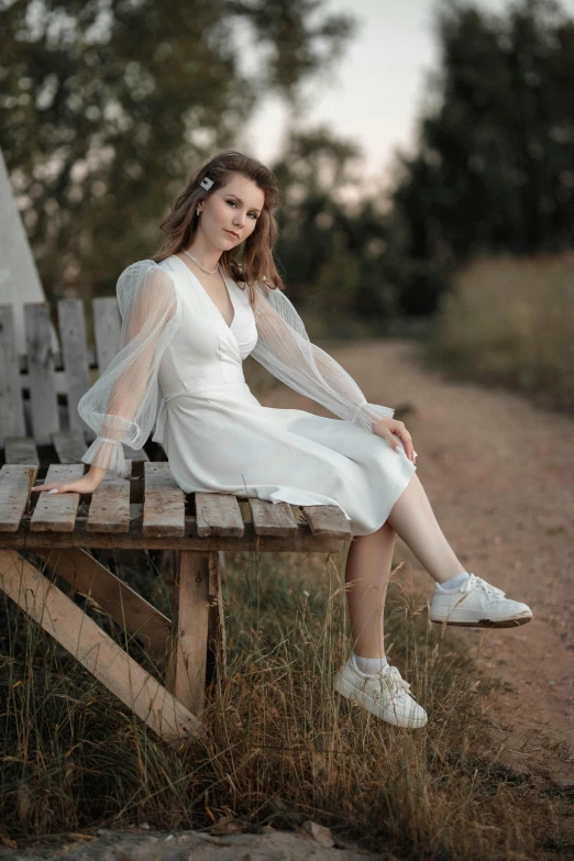 a woman sitting on a bench next to trees