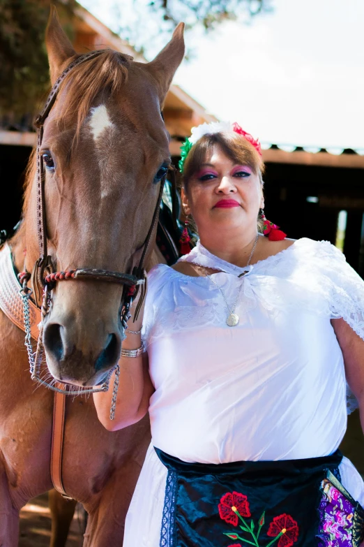 a woman standing next to a brown horse wearing a costume