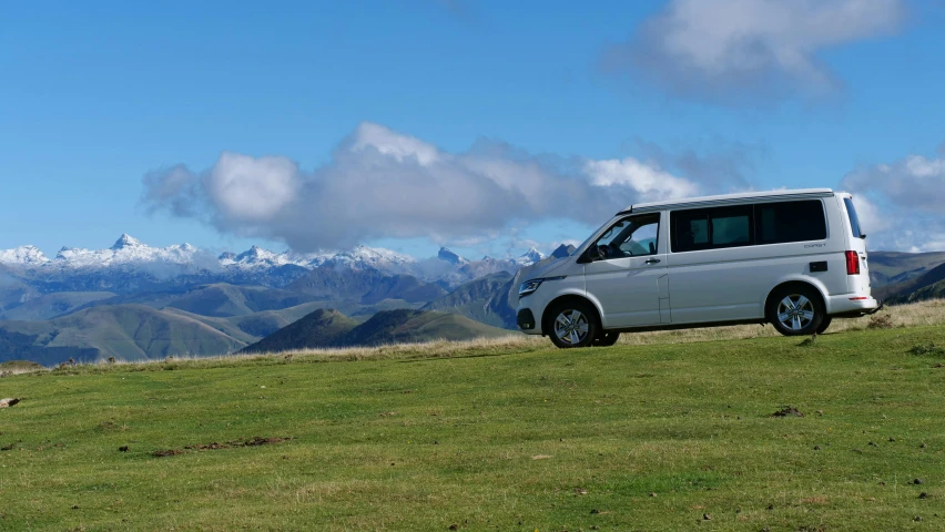 a van parked in front of a scenic mountain range