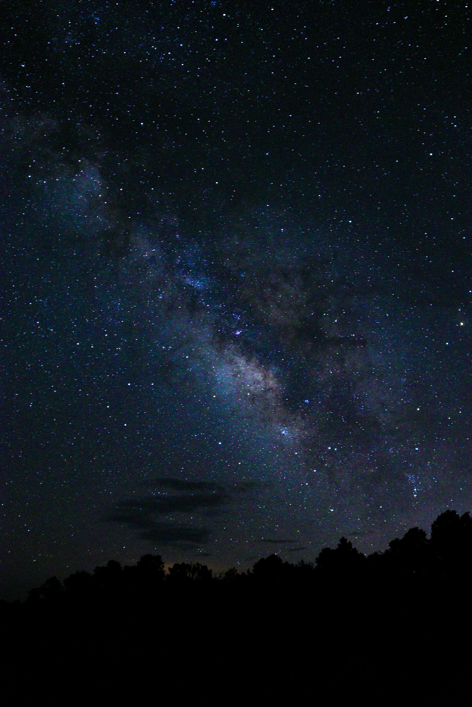 a night sky with stars shining on a mountain