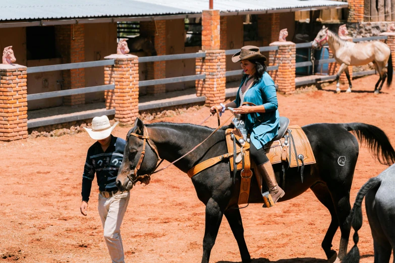 a woman walking around with a boy on a horse