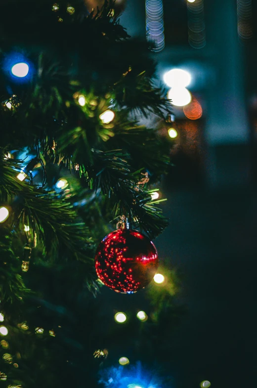 closeup of a lighted christmas ornament on a tree