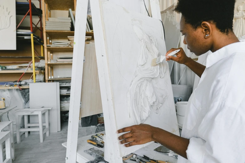 a man painting a white heart in a studio