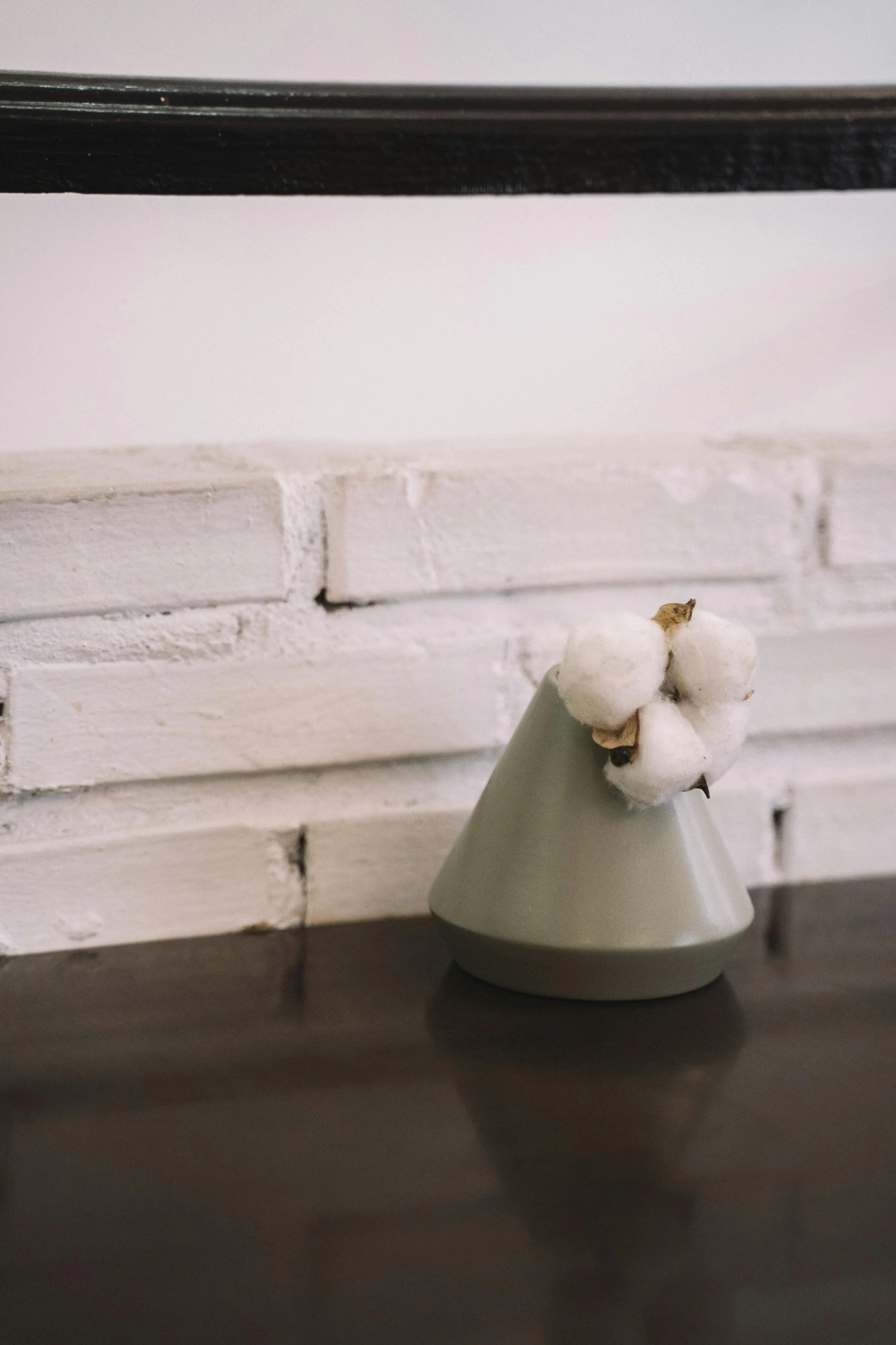 a white object sitting on a table, next to a mirror