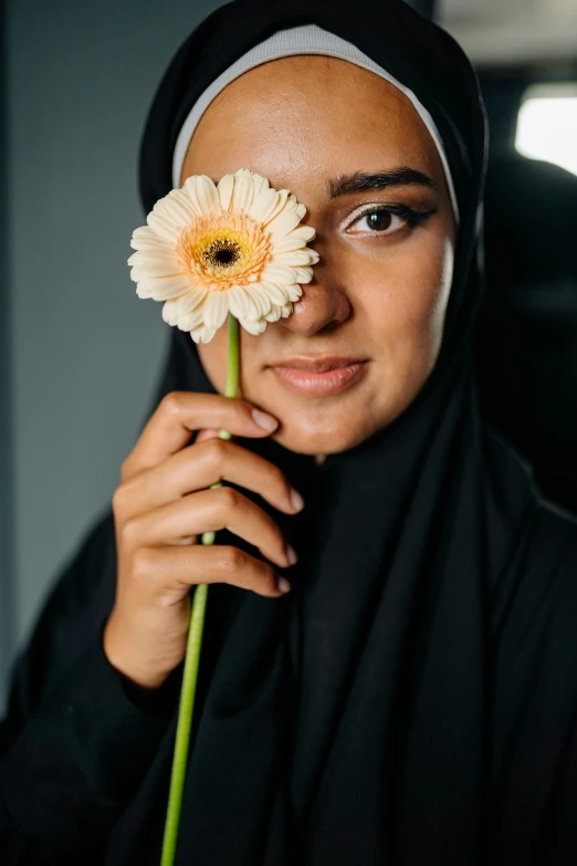a woman with a flower in her eye and black top