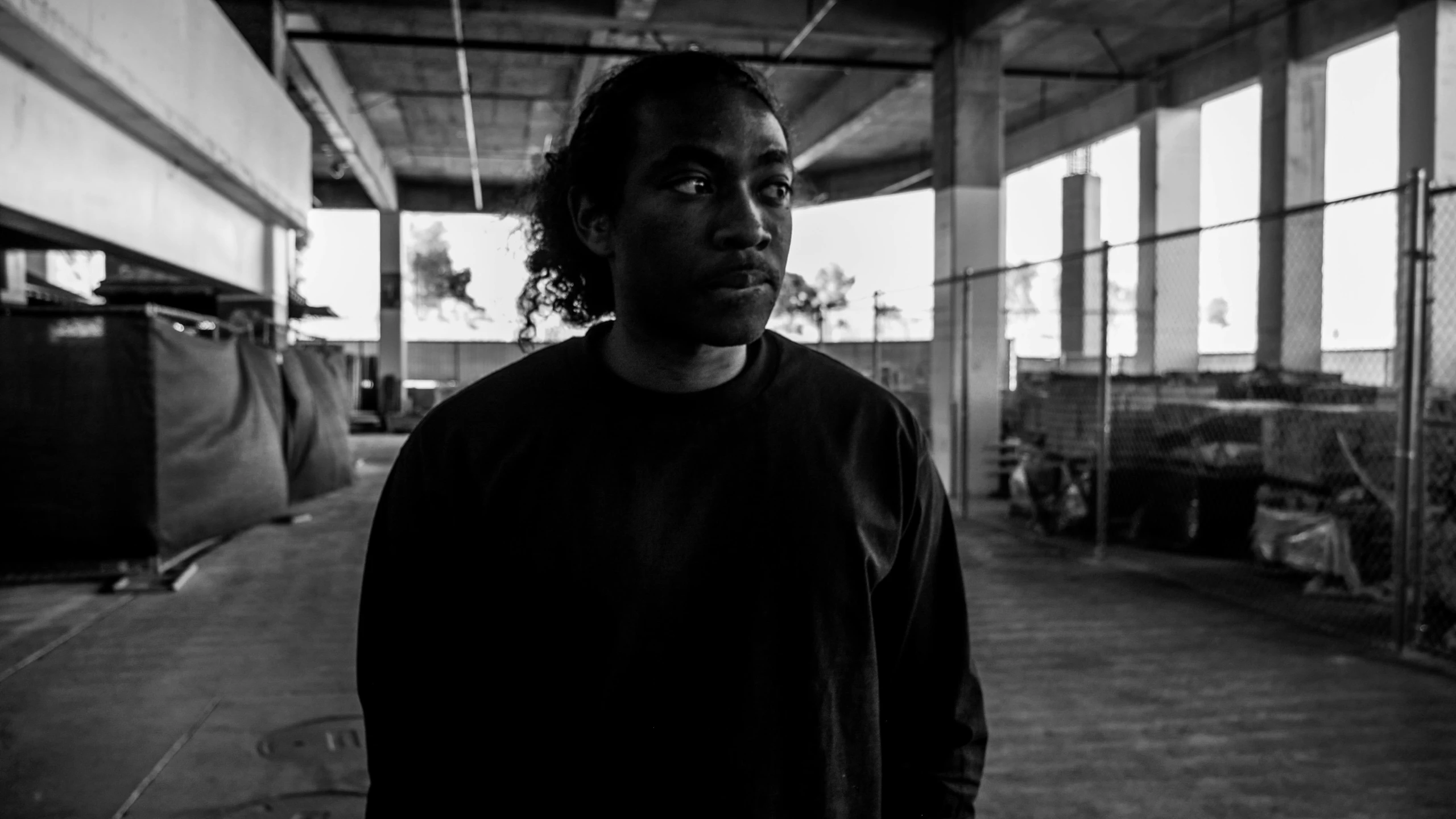 a man stands outside in a parking garage