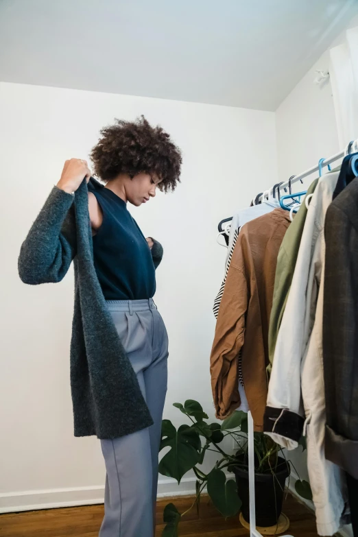 a woman is trying to put on her blue sweater