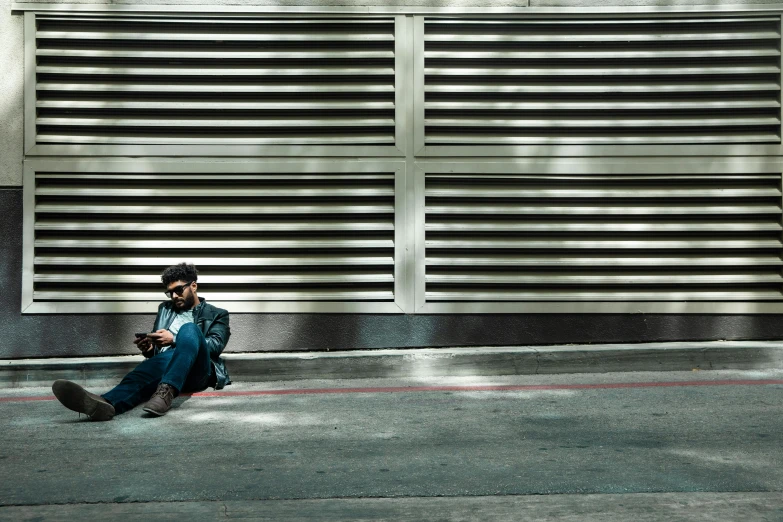 a man sitting in the street holding his phone