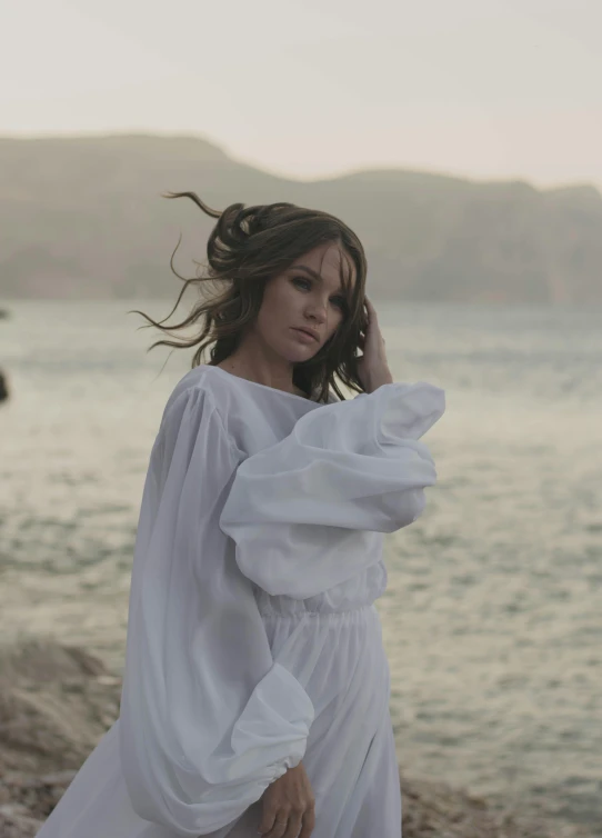 woman wearing a white dress posing on the shore