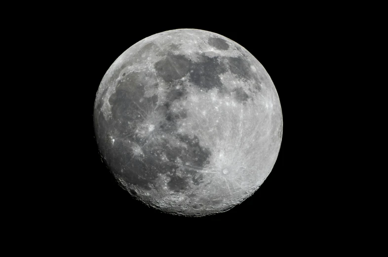 a large dark moon on black with a few clouds