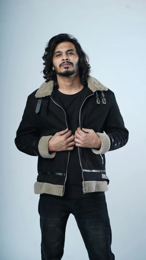 a man wearing black clothing with a fur lined hoodie