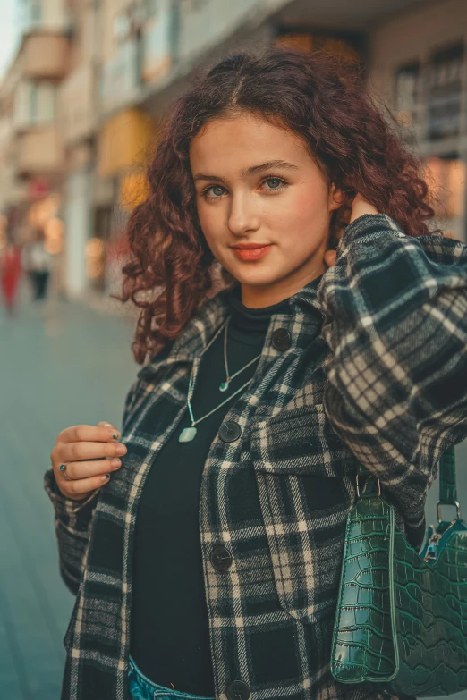 a woman is wearing a plaid jacket and black top