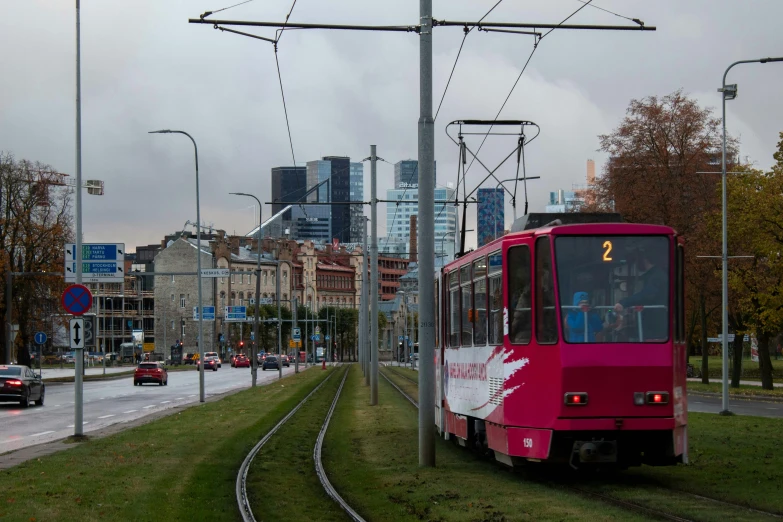 a red bus going down the tracks in a city