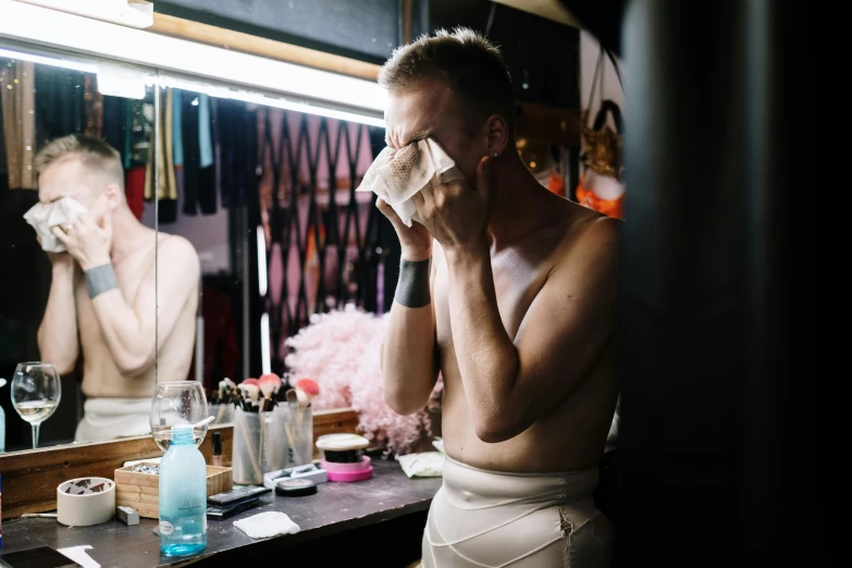 a man in his underwear standing in front of a mirror