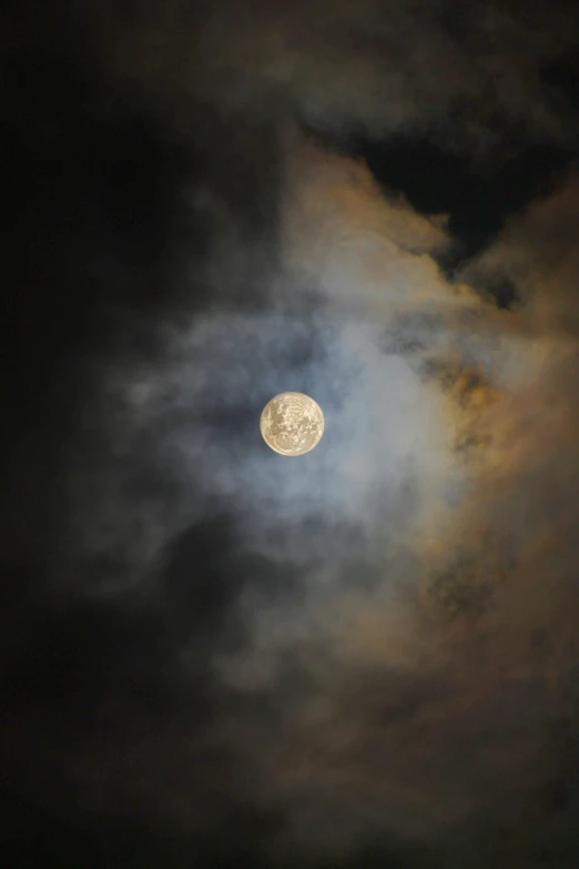 the moon is rising through a cloud filled sky