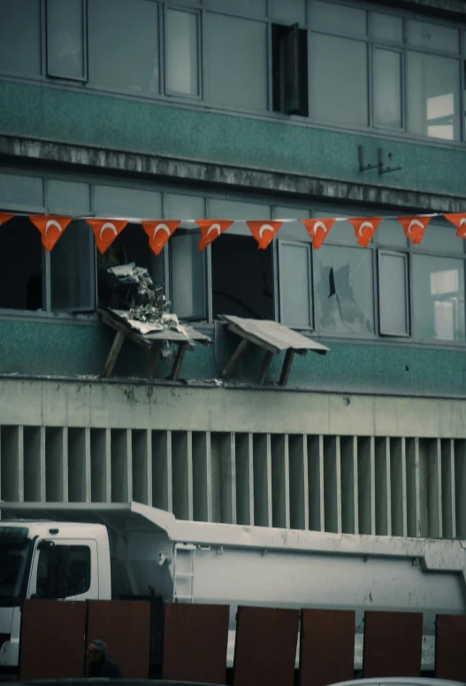 two benches, one of them in between the windows and the other at the top of a building