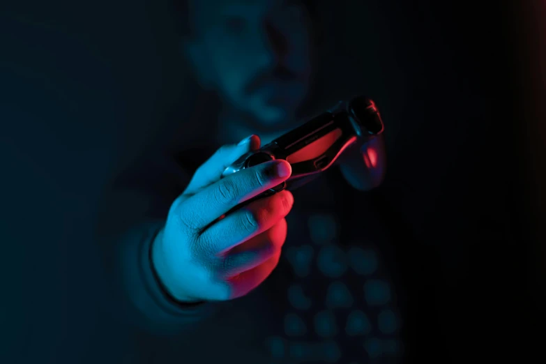 a man in a dark room holds his cell phone